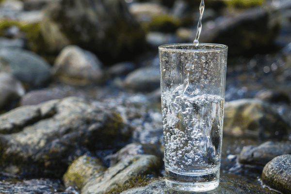 copo de agua com pedras ao fundo